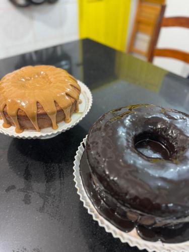 zwei Donuts auf Papptellern auf einem Tisch in der Unterkunft Pousada Tropical Araçatiba in Praia de Araçatiba