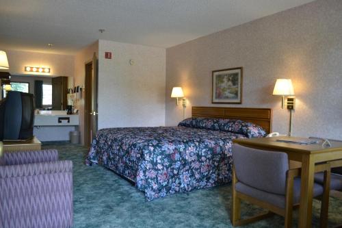 Habitación de hotel con cama y escritorio en Apple Blossom Inn en Eureka Springs