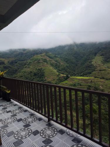 a balcony with a view of the mountains at Dad's Place Lodge and Restaurant in Banaue