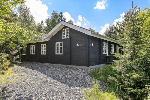 a black house with white windows on a gravel driveway at LF16183-Logstor-Monasvej-1 in Løgstør