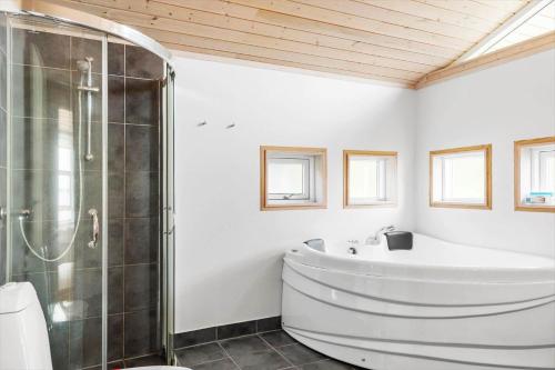 a white bathroom with a tub and a shower at LF14194-Roslev-Bagvejen-26 in Roslev