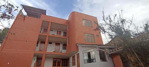 an orange building with a lot of windows at Casa Tejedora in Chinchero