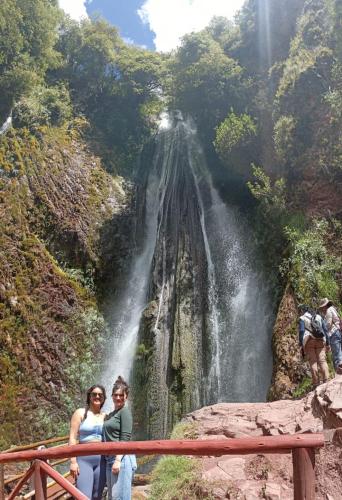 two women standing in front of a waterfall at Casa Tejedora in Chinchero