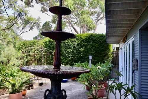 a bird bath sitting in the middle of a yard at The Gallery Beach Apartment in Kiama