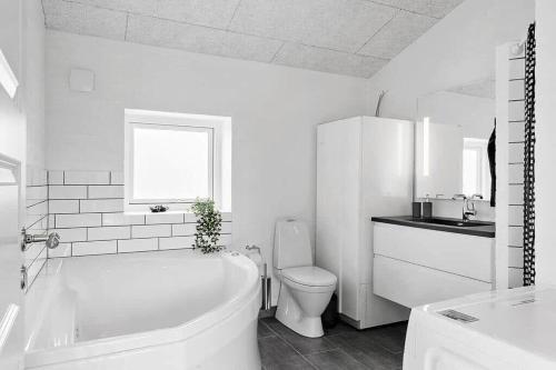 a bathroom with a tub and a toilet and a sink at LF12172-Vinderup-Strandlyst-29 in Vinderup
