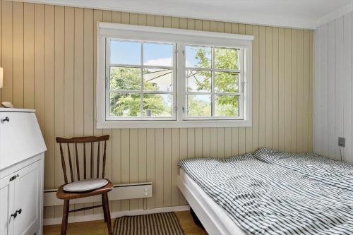 a bedroom with a bed and a chair and a window at LF622-Hurup-Bakkesiden-22 in Hurup