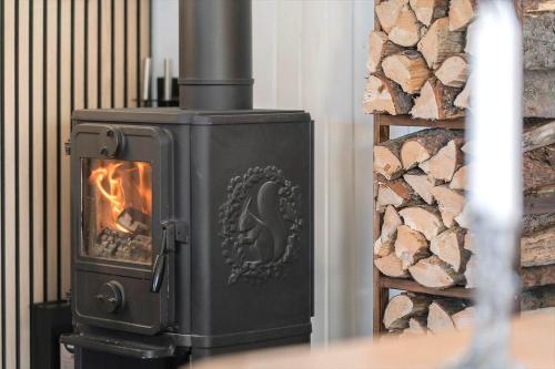 a black stove with a fire in a room at LF11731-Struer-Skraningen-31 in Struer
