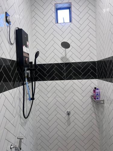 een badkamer met een zwart-witte tegelmuur bij Ariyanie Roomstay 2 in Kuala Terengganu