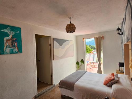 - une chambre avec un lit et une porte donnant sur une terrasse dans l'établissement La Casita de Arte, à San Cristóbal de Las Casas