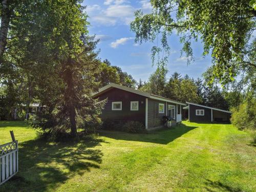 a house on a grassy yard with a fence at 6 person holiday home in Glesborg in Glesborg
