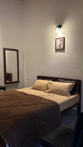 a bedroom with a large bed with a mirror and a mirror at Palms by Kalpana in Mudigere