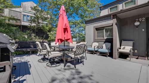 a patio with a table with chairs and an umbrella at Cozy Modern Camelback House in Tannersville