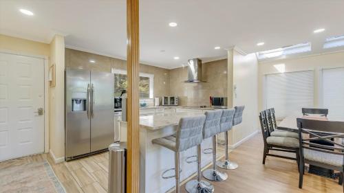 a kitchen with a bar with chairs and a refrigerator at Cozy Modern Camelback House in Tannersville