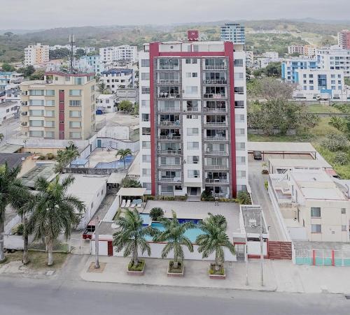 a tall building with palm trees in front of it at Departamento excelente vista y ubicación en Tonsupa in Tonsupa