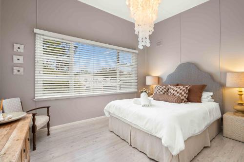 una camera da letto con un letto grande e una finestra di Whitewash Cottage by Experience Jervis Bay a Huskisson