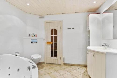 a bathroom with a tub and a toilet and a sink at LF483-Snedsted-Bjergvej-8 in Snedsted