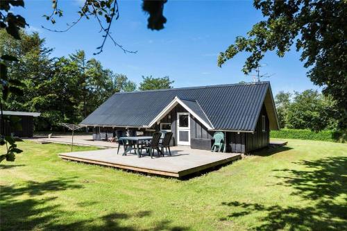 a small house with a deck and a table at LF12017-Spottrup-Albaekparken-144 in Spottrup