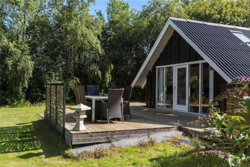 a small cabin with a table and chairs on a deck at LF12017-Spottrup-Albaekparken-144 in Spottrup