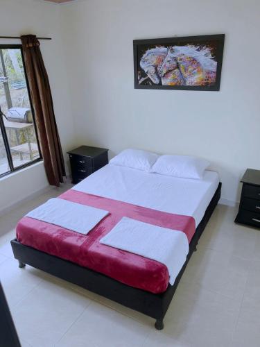 a bedroom with a bed with a red and white blanket at Romantic Glamping - Vista Impresionante Villeta Jacuzzi in Villeta