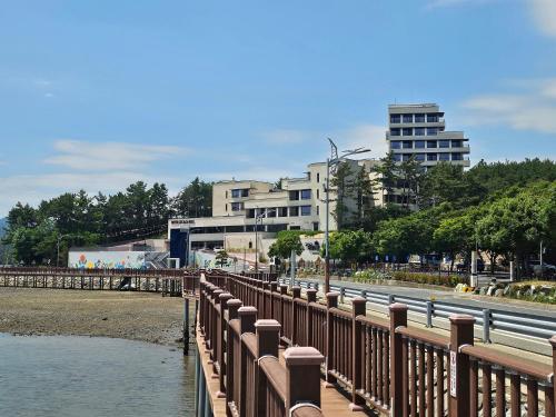 a bridge over a river with buildings in the background at Goseong-gun Youth Hostel 