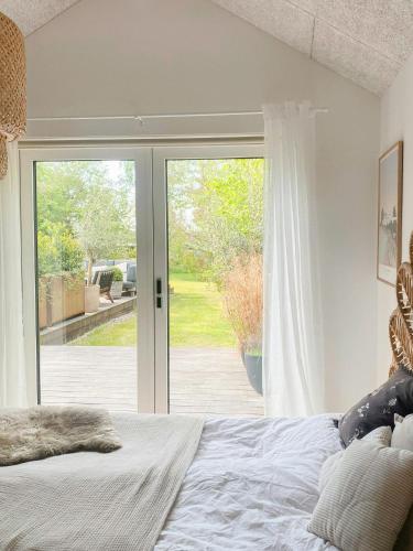 a bedroom with a bed and a sliding glass door at Modern Holiday Home By Holbæk Fjord in Holbæk