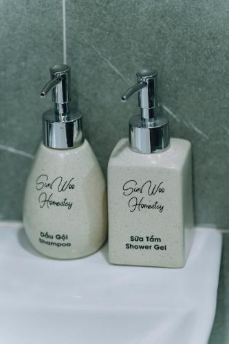 two soap dispensers sitting on top of a sink at Catba SunWoo Homestay & Hotel in Cat Ba