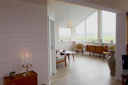 a living room with a table and chairs and windows at LF11932-Struer-Gl-Landevej-23 in Struer