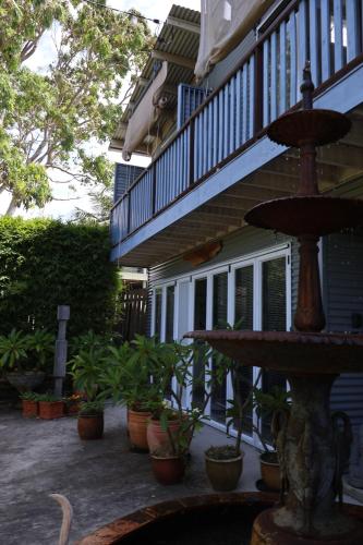 a fountain in front of a house with potted plants at The Gallery Beach Apartment in Kiama