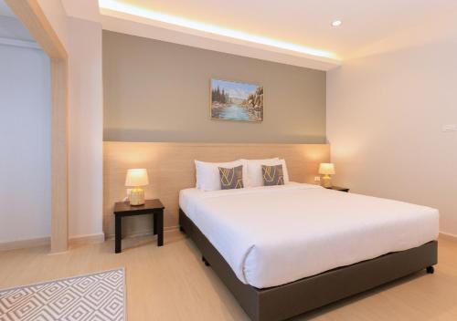 Un dormitorio con una cama grande y dos lámparas sobre mesas. en Baan Phor Phan Hotel, en Khon Kaen
