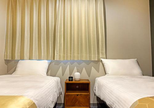a bedroom with two beds and a window at Stay SAKURA Kyoto Station Shichijo in Kyoto