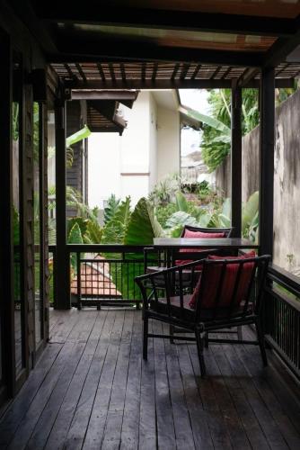 a porch with two chairs and a table on it at Baan Saen Fang Chiang Mai in Chiang Mai