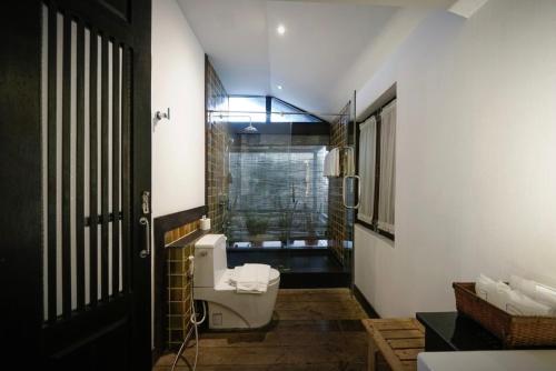 ein Badezimmer mit Toilette und Waschbecken und einem Fenster in der Unterkunft Baan Saen Fang Chiang Mai in Chiang Mai