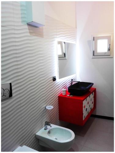 a bathroom with a red sink and a red cabinet at Corte del Pascià in Lecce