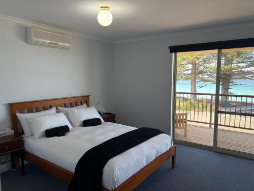 a bedroom with a large bed and a balcony at Tumby Bay Hotel Seafront Apartments in Tumby Bay