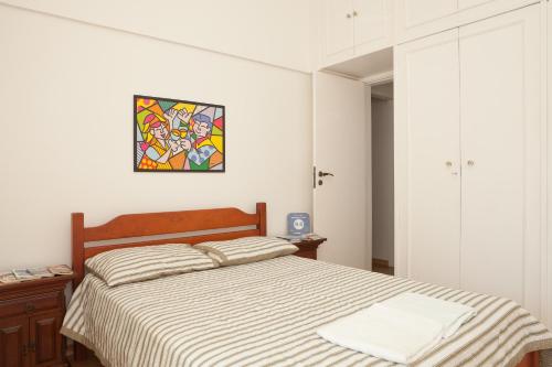 Apartamento completo na praia de Copacabana 02 Suites com vista mar em andar alto, ar, wifi , netflix, pauloangerami RMVC18 في ريو دي جانيرو: غرفة نوم مع سرير ونافذة زجاجية ملطخة