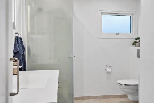 a white bathroom with a toilet and a window at LF11101-Struer-Blabaervej-12 in Struer