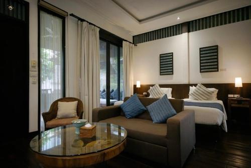a living room with a couch and a coffee table at Baan Saen Fang Chiang Mai in Chiang Mai