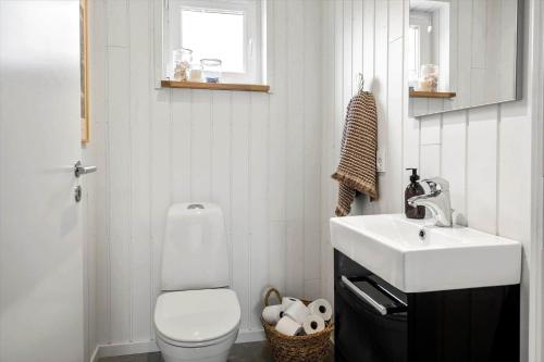 a bathroom with a white toilet and a sink at LF10058-Thyholm-Fyrrevej-17 in Thyholm