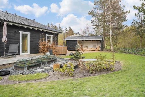 a garden in front of a black house at LF10058-Thyholm-Fyrrevej-17 in Thyholm