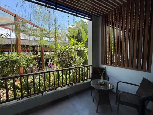 a balcony with a table and a large window at Santai Toraja in Rantepao