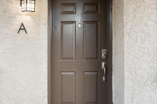a brown door on a white building with a sign on it at Coastal Retreat w Pool Spa BBQ Near Beaches Golf Courses Ritz Pointe Condo by AvantStay in Dana Point