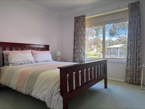 a bedroom with a bed and a large window at Grand Spindrift - Entire Waterfront House in Malua Bay