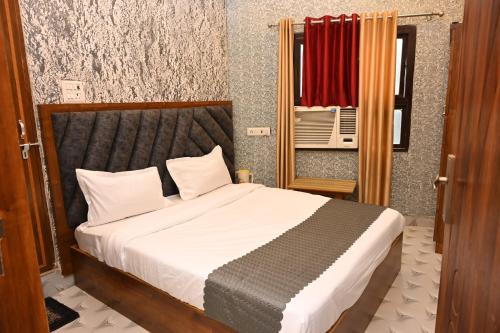 a bedroom with a bed and a window and a mirror at Sawaria Residency in Varanasi