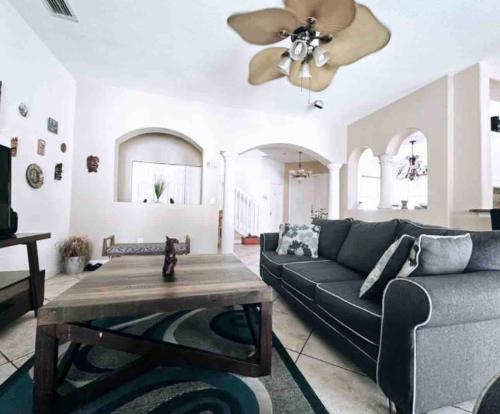 a living room with a couch and a ceiling fan at The Miami Lakes Pool House in Miami Lakes