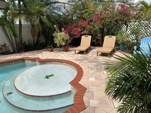 a patio with two chairs and a swimming pool at The Miami Lakes Pool House in Miami Lakes