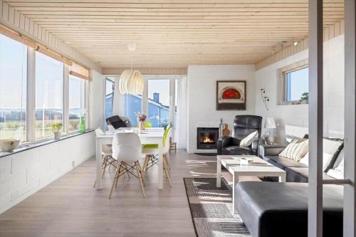a living room with a table and a fireplace at LF888-Snedsted-Over-Reese-5 in Snedsted