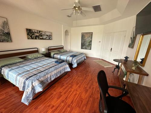a bedroom with two beds and a ceiling fan at The Miami Lakes Pool House in Miami Lakes