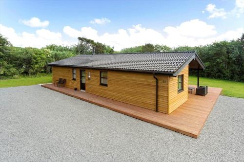 a large wooden cabin with a wooden deck at LF143-Vestervig-Gunhildsvej-43 in Vestervig