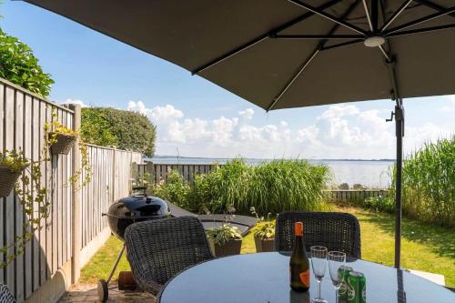 a table and chairs with an umbrella on a patio at LF13171-Nykobing-M-Fjordvej-34 in Nykøbing Mors