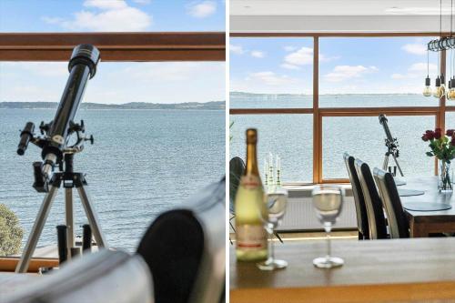 a table with a bottle of wine and a view of the water at LF13171-Nykobing-M-Fjordvej-34 in Nykøbing Mors